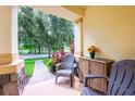 Cozy front porch featuring comfortable seating, decorative plants, and a serene view of the neighborhood at 14128 Avenue Of The Grvs, Winter Garden, FL 34787