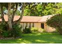 The house features a well-manicured lawn with mature trees and shrubs surrounding the property at 1509 Huntington St, Deltona, FL 32725