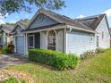 Side view of light-blue single Gathering home with a manicured green lawn and dark gray roof at 1751 Chatham Cir, Apopka, FL 32703