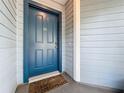 Stylish blue front door of a home with a 'Welcome' mat, set against light-blue siding at 1751 Chatham Cir, Apopka, FL 32703