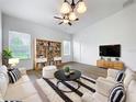 Bright living room boasts hardwood floors, white furniture, and a ceiling fan at 2092 Switch Grass Cir, Ocoee, FL 34761