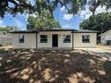 Charming single-story home with white exterior, complemented by a dark roof and inviting front entrance at 212 Dorothy St, Auburndale, FL 33823