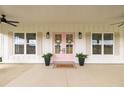 Inviting front porch featuring pink double doors, potted plants, and a charming welcome mat at 22212 Sw 210Th Ave, Dunnellon, FL 34431