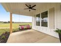 Relaxing porch with a porch swing, ceiling fan, and views of the surrounding fields at 22212 Sw 210Th Ave, Dunnellon, FL 34431