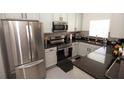 Modern kitchen featuring stainless steel appliances and dark countertops, providing a sleek and functional space at 2241 Retreat View Cir, Sanford, FL 32771