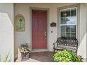 Welcoming front entrance featuring a brick-paved porch, a decorative bench, and a solid wood door at 2759 Purple Meadow Ct, Minneola, FL 34715