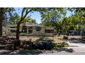 Exterior shot of the property shows an old home with wood stacked and garbage bags in front at 3914 W Robinson St, Orlando, FL 32805
