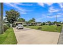 Single story home with well-kept lawn and mature trees; car parked in a long driveway at 426 Illinois Ave, St Cloud, FL 34769