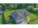 Aerial view of a well-maintained home with a large yard, black roof, and fenced perimeter at 4911 Ne 7Th St, Ocala, FL 34470