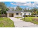 Inviting single-story home featuring a well-maintained front yard, covered carport, and charming entryway at 7330 Canal Dr, Sanford, FL 32771