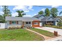 Charming single-story home featuring a landscaped front yard, updated siding, and a walkway to the front door at 840 Bethune Dr, Orlando, FL 32810