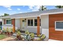 A close-up showing modern exterior details with updated siding and landscaping along the front of the house at 840 Bethune Dr, Orlando, FL 32810