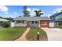 Charming single-story home featuring a landscaped front yard, updated siding, and a walkway to the front door at 840 Bethune Dr, Orlando, FL 32810