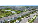 Expansive aerial view showcasing a well-planned community with modern townhomes, scenic ponds, and ample green spaces at 850 Pebble Beach Dr, Davenport, FL 33896