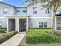 Stylish townhouse entrance featuring modern architecture, manicured landscaping, and a welcoming walkway to the front door at 850 Pebble Beach Dr, Davenport, FL 33896