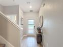 Bright entryway with neutral tones, tiled floor, decorative mirror, and a clear view of the front door at 850 Pebble Beach Dr, Davenport, FL 33896