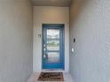 Stylish blue front door with glass panes and 'Home Sweet Home' mat, showcasing a welcoming entrance at 850 Pebble Beach Dr, Davenport, FL 33896