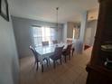 Inviting dining room with tile floors, chandelier, and a large window that provides natural light at 8509 Sw 136Th Loop, Ocala, FL 34473