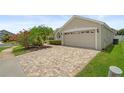 Paver driveway leading to a two-car garage on a well-maintained property at 9003 Pecky Cypress Way, Orlando, FL 32836