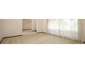 Bright living room featuring neutral carpet and large windows with sheer curtains at 9206 Everwood St, Orlando, FL 32825