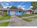 Cozy single-Gathering home featuring a light blue exterior, one-car garage, and a well-maintained front lawn at 978 Calanda Ave, Orlando, FL 32807