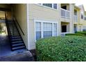 Exterior side view of a condo building with stairs leading to upper units and well-maintained landscaping at 1031 S Hiawassee Rd # 2514, Orlando, FL 32835