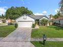 Charming single-story home with brick driveway, lush landscaping, and a classic mailbox at 1044 Dees Dr, Oviedo, FL 32765