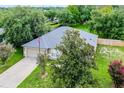 Aerial view of a single-story home with lush greenery and mature trees in a serene neighborhood at 1113 Canopy Oaks Dr, Minneola, FL 34715