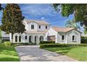 Two-story home with white stucco and a clay tile roof, complemented by a manicured lawn and brick driveway at 1394 Grove Ter, Winter Park, FL 32789
