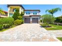 Beautiful home featuring a paved driveway leading to a two-car garage and lush, mature landscaping at 16210 Ravenna Ct, Montverde, FL 34756