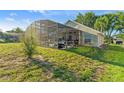 Screened-in pool area featuring a covered patio, lush landscaping, and plenty of space for entertaining at 1956 Southern Dunes Blvd, Haines City, FL 33844