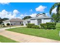 Landscaped lawn complements this home with a brick driveway and tasteful shrubbery at 25105 Laurel Valley Rd, Leesburg, FL 34748
