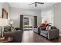 Bright living room boasts hardwood floors, neutral paint, contemporary furnishings, and sliding doors to the outdoors at 3618 Pompano Ct, Gotha, FL 34734