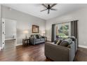 Inviting living room with hardwood floors, ceiling fan, neutral paint, and large window with views of the backyard at 3618 Pompano Ct, Gotha, FL 34734