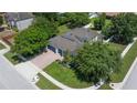Aerial view of a well-maintained home with a three-car garage, paver driveway, and lush landscaping at 3994 Knott Dr, Apopka, FL 32712