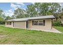 A charming, ranch-style home with a metal roof, geometric details, and a well-maintained lawn at 4085 Cypress Bend, Geneva, FL 32732