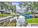 Picturesque waterfront view of a canal with docks and several boats docked, lush green banks on either side at 413 Harbour Oaks Pointe Dr, Edgewood, FL 32809