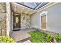 Inviting front entrance featuring a stone facade, decorative door, and manicured landscaping at 413 Harbour Oaks Pointe Dr, Edgewood, FL 32809