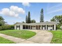 Inviting single-story home featuring a circular driveway, fresh exterior paint, and charming shutters at 4611 Cranston Pl, Orlando, FL 32812