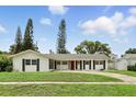 A bright and welcoming single-story home with a red front door and freshly mowed lawn at 4611 Cranston Pl, Orlando, FL 32812