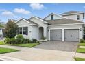 Charming single-Gathering home featuring a two-car garage, brick driveway, and beautifully landscaped front yard at 5314 Golden Apple Dr, Winter Garden, FL 34787