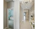 Bright hallway with tile flooring, chandelier lighting, and entry view into a bedroom with a ceiling fan at 5314 Golden Apple Dr, Winter Garden, FL 34787