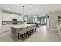Open-concept kitchen featuring a large island with seating, stainless steel appliances, and backyard views at 5314 Golden Apple Dr, Winter Garden, FL 34787