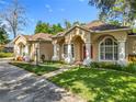 Charming home featuring stucco exterior, arched columns, and well-maintained landscaping at 5489 Glen Oak Place, Sanford, FL 32771