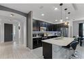 Modern kitchen featuring an island with barstool seating, stainless steel appliances, and sleek black cabinetry at 654 Star Magnolia Dr, Kissimmee, FL 34744
