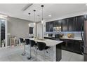 Open concept kitchen featuring an island with seating, stainless steel appliances, and stylish pendant lighting at 654 Star Magnolia Dr, Kissimmee, FL 34744