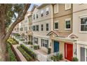 Inviting townhouse complex with well-manicured landscaping, colorful doors, and tiled roofs at 661 Hangnest Ln, Lake Mary, FL 32746