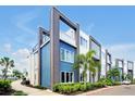 Modern condo building with a sleek design, featuring blue accents, balconies, and lush landscaping at 7770 Sandy Ridge Dr # 117, Reunion, FL 34747