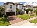 Beautiful two-story home showcasing a well-kept lawn, brick-paved driveway, and an attached two-car garage at 8066 Ludington Cir, Orlando, FL 32836