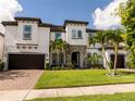 Attractive two-story home with a well-manicured lawn, brick-paved driveway, and an attached two-car garage at 8066 Ludington Cir, Orlando, FL 32836